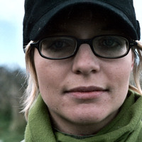 Headshot colour photograph of Pan Pan producer and manager, Aoife White. White is facing the camera, wearing hat and glasses.
