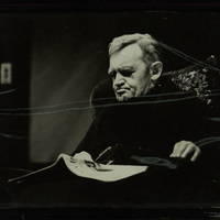 Black and white photograph of Barry Fitzgerald seated at on an arm chair with a news paper on his lap.