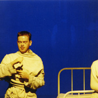 Colour photograph of two actors on a bed in The Man With Two Kisses by Pan Pan Theatre Company